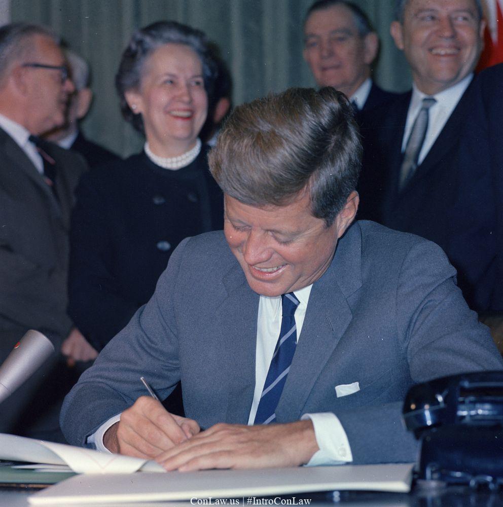 In 1961, President John F. Kennedy issued Executive Order No. 10925, which barred government contractors from engaging in racial discrimination.
